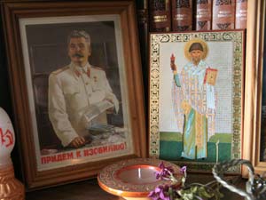 В комнате бывшего ветеринара, а ныне архимандрита Петра Кучера иконостас стоит рядом с портретом Сталина.