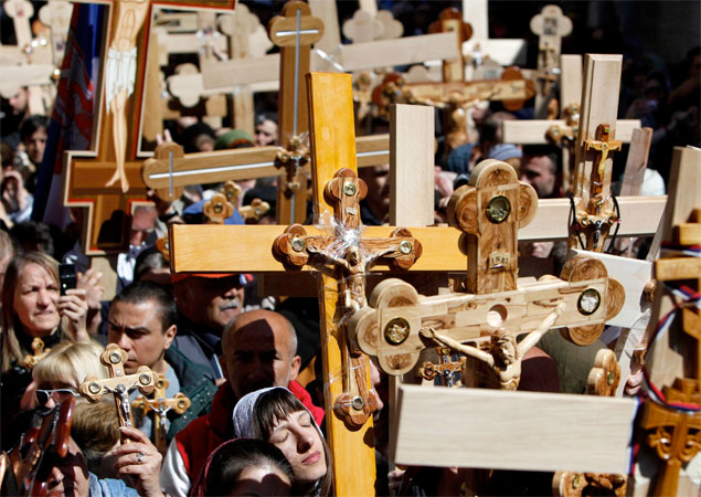 Тысячи христиан следуют с крестами по Виа Долороса - улице в Старом городе Иерусалима, по которой, как считается, пролегал путь Иисуса Христа к месту распятия